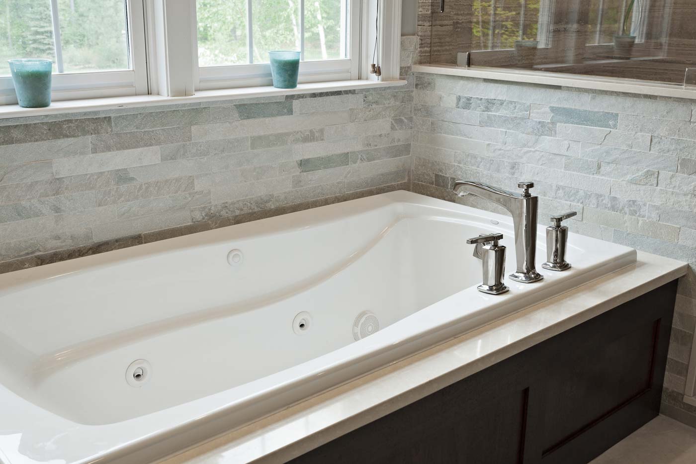 Mahogany bath with beautiful textured tile surround