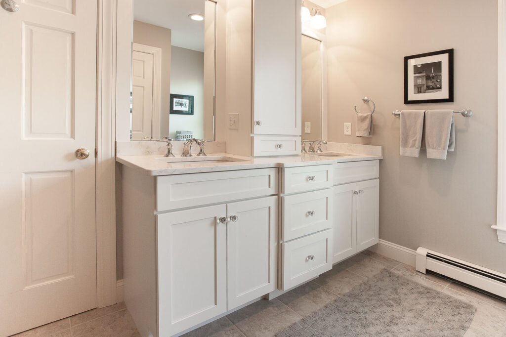 White bathroom cabinetry with twin sinks and center storage